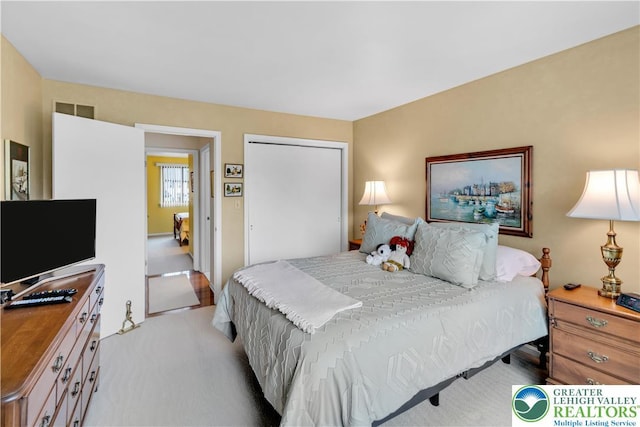 bedroom featuring a closet and light colored carpet