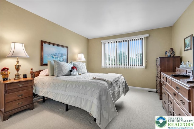 bedroom with light carpet and baseboards