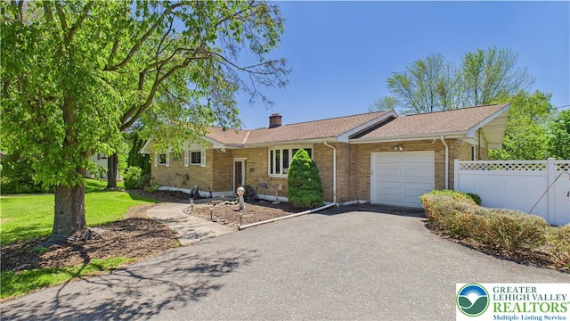 4168 Orefield Rd, South Whitehall Twp, PA 18104 - ranch-style home featuring a garage, fence, a chimney, driveway, and brick siding