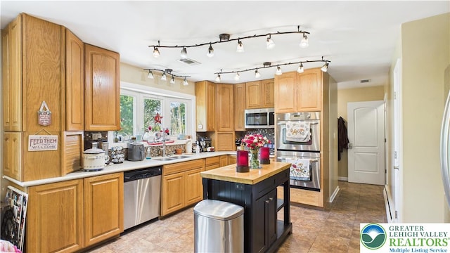 4168 Orefield Rd, South Whitehall Twp, PA 18104 - kitchen featuring appliances with stainless steel finishes, a sink, wooden counters, tasteful backsplash, and rail lighting