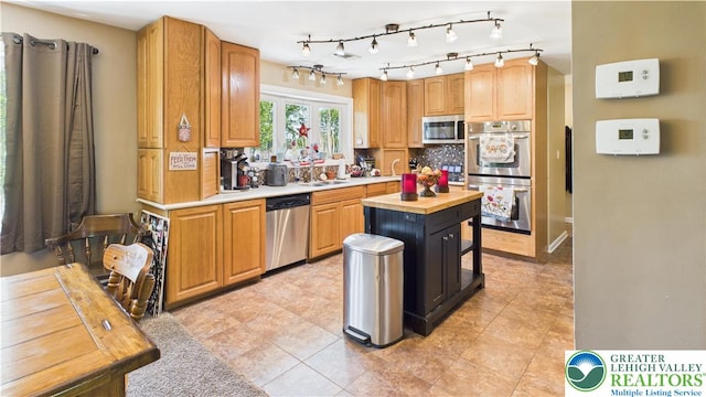 4168 Orefield Rd, South Whitehall Twp, PA 18104 - kitchen with appliances with stainless steel finishes, a sink, decorative backsplash, butcher block counters, and light tile patterned flooring
