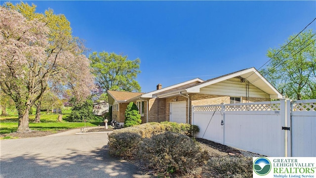 4168 Orefield Rd, South Whitehall Twp, PA 18104 - view of home's exterior featuring a gate, a garage, fence, and brick siding
