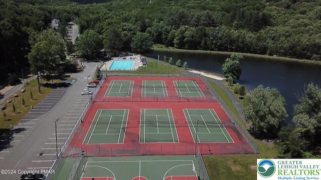 drone / aerial view of a heavily wooded area and a nearby body of water