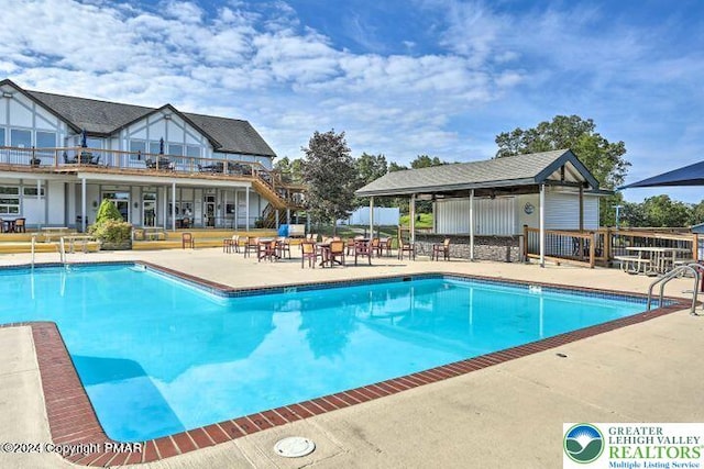 community pool with a patio area and fence