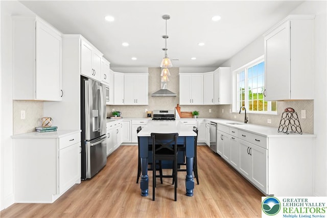 4779 Farrcroft Dr Unit 90, Forks Twp, PA 18040 - kitchen with appliances with stainless steel finishes, a sink, wall chimney range hood, light wood-style flooring, and recessed lighting