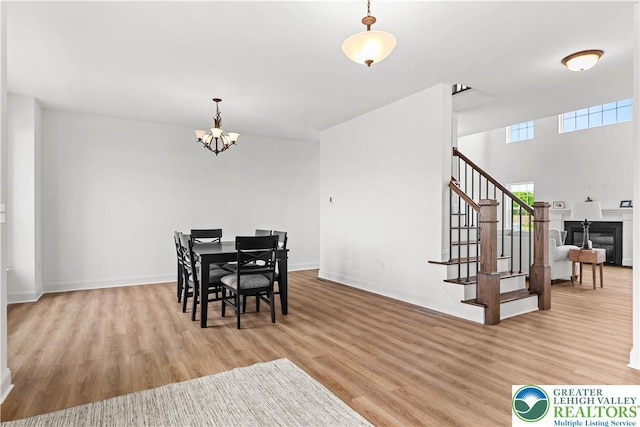 4779 Farrcroft Dr Unit 90, Forks Twp, PA 18040 - dining space featuring light wood-style floors, stairway, a chandelier, baseboards, and a glass covered fireplace