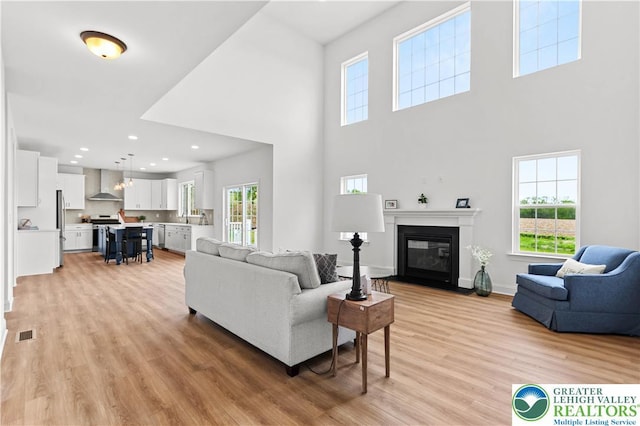 4779 Farrcroft Dr Unit 90, Forks Twp, PA 18040 - living area featuring light wood finished floors, a fireplace with flush hearth, a high ceiling, recessed lighting, and baseboards