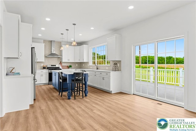4779 Farrcroft Dr Unit 90, Forks Twp, PA 18040 - kitchen featuring wall chimney range hood, stainless steel appliances, white cabinets, light wood finished floors, and recessed lighting