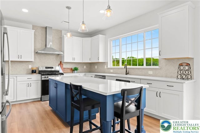 4779 Farrcroft Dr Unit 90, Forks Twp, PA 18040 - kitchen featuring wall chimney exhaust hood, stainless steel appliances, light countertops, a sink, and white cabinets