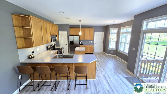 kitchen with stainless steel appliances, a sink, baseboards, open shelves, and light countertops