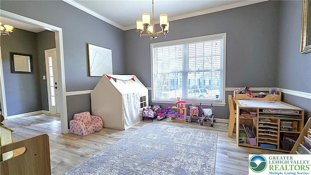 game room with a chandelier, ornamental molding, wood finished floors, and baseboards