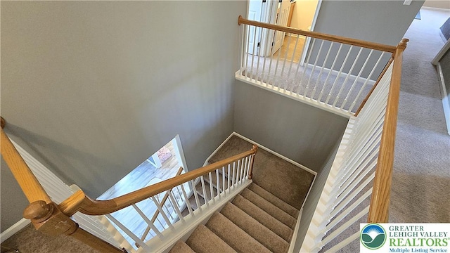 stairway featuring carpet floors and baseboards