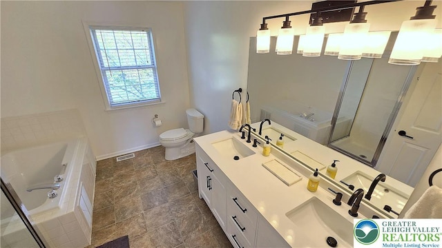 bathroom with baseboards, a bath, toilet, double vanity, and a shower with shower door