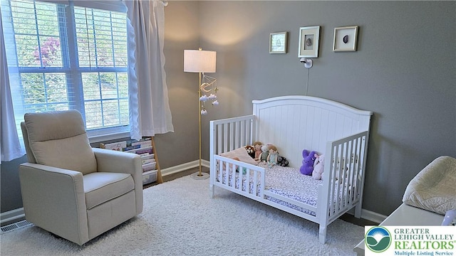 bedroom featuring baseboards and a crib