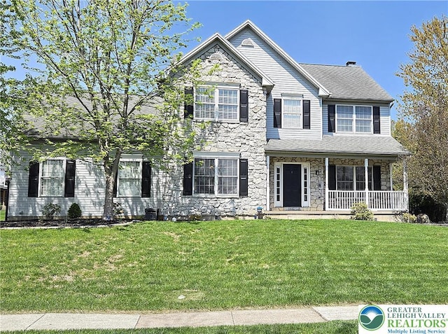 view of front of house with stone siding, a porch, and a front lawn