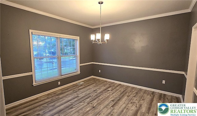 unfurnished room featuring wood finished floors, a chandelier, crown molding, and baseboards