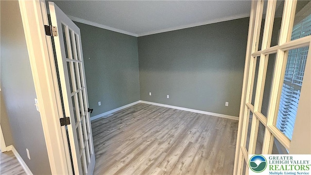 unfurnished room featuring ornamental molding, wood finished floors, baseboards, and french doors