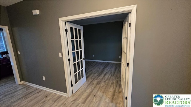 hall with wood finished floors and baseboards