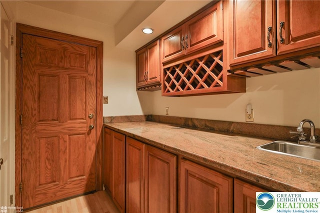 1551 Wethersfield Dr, South Whitehall Twp, PA 18104 - kitchen featuring a sink, brown cabinets, recessed lighting, light wood-type flooring, and light stone countertops