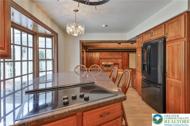 1551 Wethersfield Dr, South Whitehall Twp, PA 18104 - kitchen featuring black appliances, light wood-style floors, brown cabinets, a chandelier, and decorative light fixtures