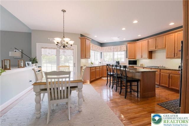dining room featuring a chandelier, light wood finished floors, recessed lighting, and baseboards