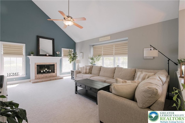 living area with high vaulted ceiling, a ceiling fan, carpet floors, and a fireplace