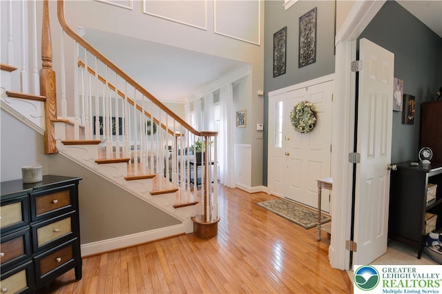 entryway with hardwood / wood-style floors, stairs, and baseboards