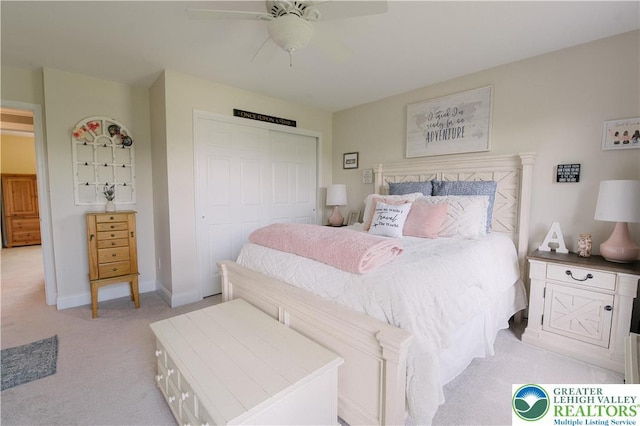 bedroom featuring light carpet, a closet, baseboards, and a ceiling fan