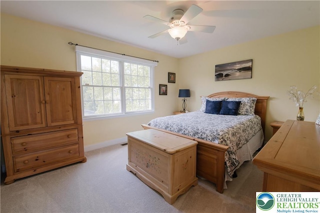 bedroom featuring light carpet, baseboards, and a ceiling fan
