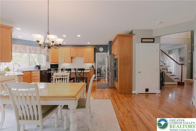 dining room featuring a chandelier, light wood-type flooring, stairs, and recessed lighting