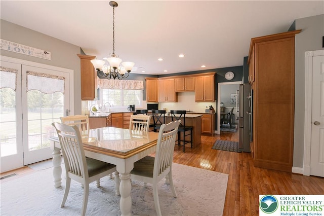 dining area with a chandelier, light wood finished floors, and recessed lighting