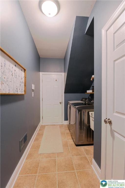 laundry area featuring washer and dryer, baseboards, and tile patterned floors