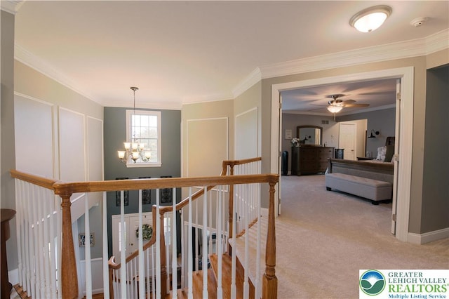 hall featuring a chandelier, crown molding, light colored carpet, and an upstairs landing
