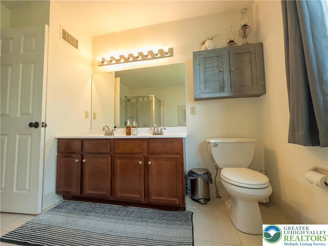 full bathroom with tile patterned floors, toilet, a shower stall, and double vanity