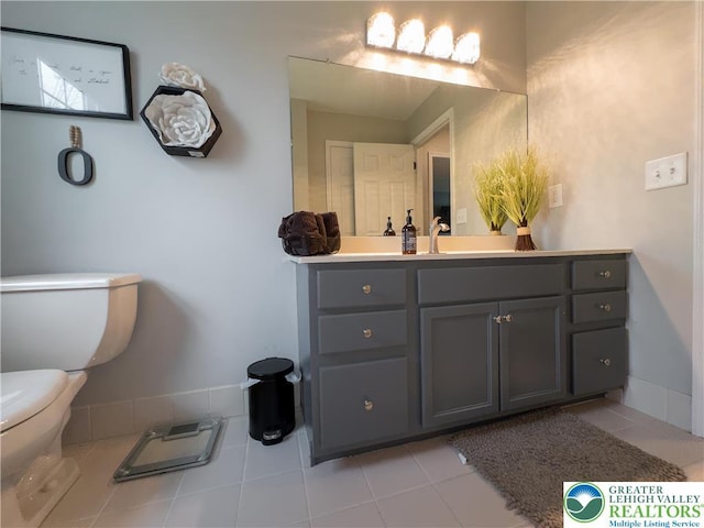 bathroom with toilet, tile patterned floors, and vanity