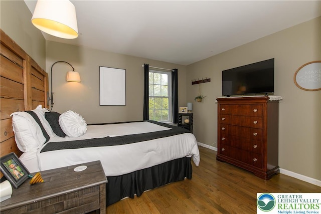 bedroom featuring wood finished floors and baseboards
