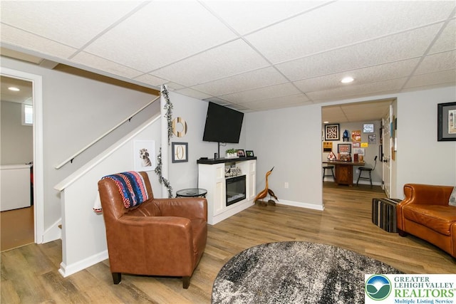 living room featuring wood finished floors, stairway, recessed lighting, a paneled ceiling, and baseboards