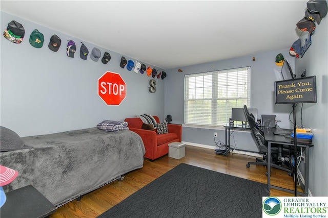 bedroom featuring wood finished floors and baseboards