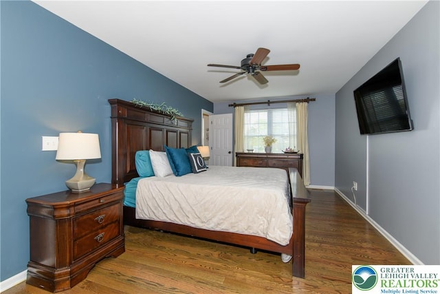 bedroom featuring wood finished floors, baseboards, and a ceiling fan
