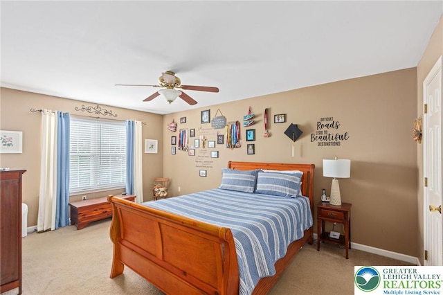 bedroom featuring light colored carpet, baseboards, and a ceiling fan