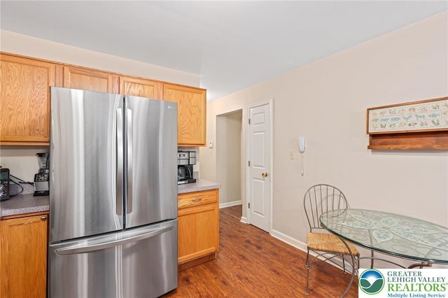 kitchen with freestanding refrigerator, dark wood-type flooring, baseboards, and light countertops