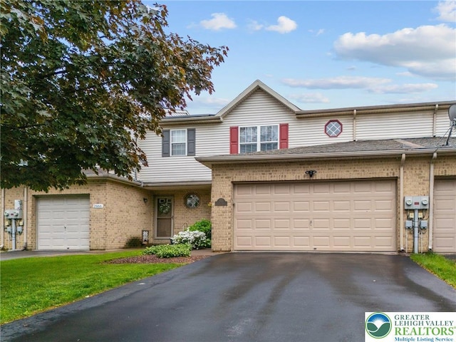 multi unit property featuring brick siding, asphalt driveway, and a garage
