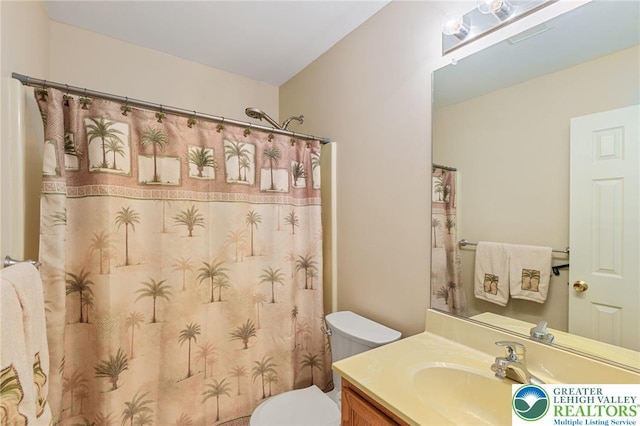 full bathroom featuring toilet, vanity, and curtained shower