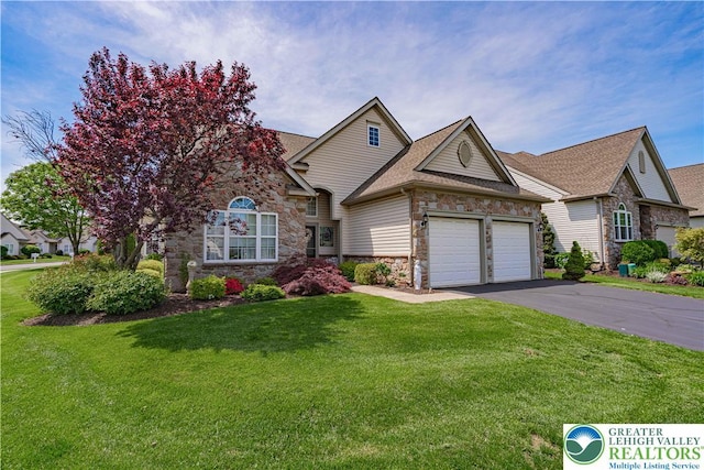 view of front of home with stone siding, an attached garage, driveway, a front yard, and a shingled roof