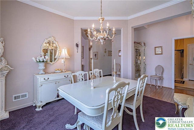 dining area with a chandelier, crown molding, dark colored carpet, and baseboards