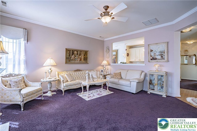 carpeted living room with a ceiling fan, crown molding, and baseboards