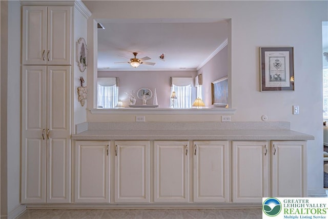 kitchen featuring light countertops, crown molding, a ceiling fan, and white cabinetry