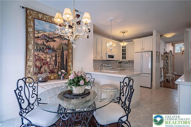 dining space featuring a chandelier and baseboards