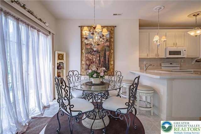 dining room with a chandelier and light tile patterned floors