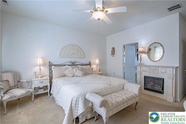 bedroom with carpet flooring, a fireplace, and a ceiling fan